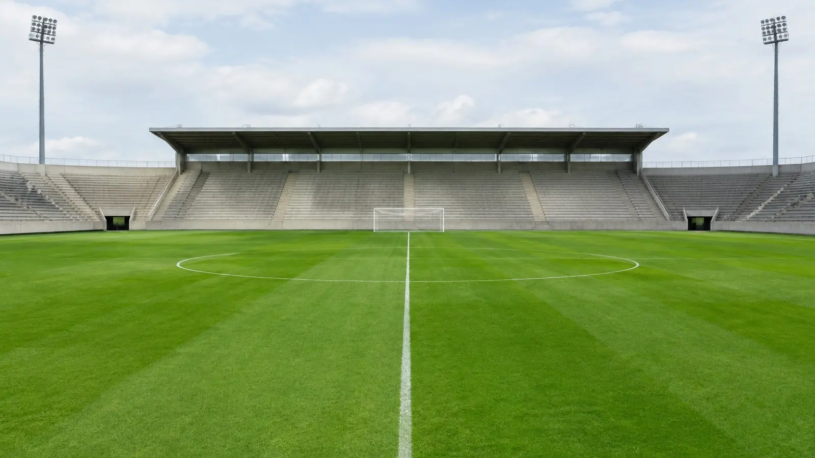 Cancha de fútbol vacía, con gradas de concreto